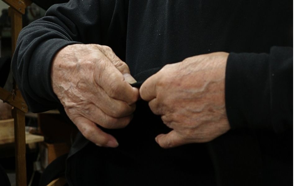 長年帽子づくりを続けてきた職人の手。フェルト帽の縁を細やかに整える作業風景。