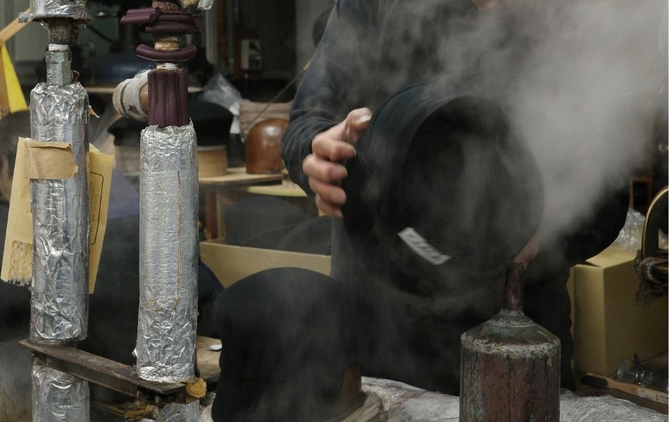 蒸気をあてながらキャスケットの形を仕上げる森安の職人。微妙な曲線を手でつくる工程。